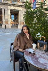 a lady in a brown tencel wool jacket and a pair of black pants